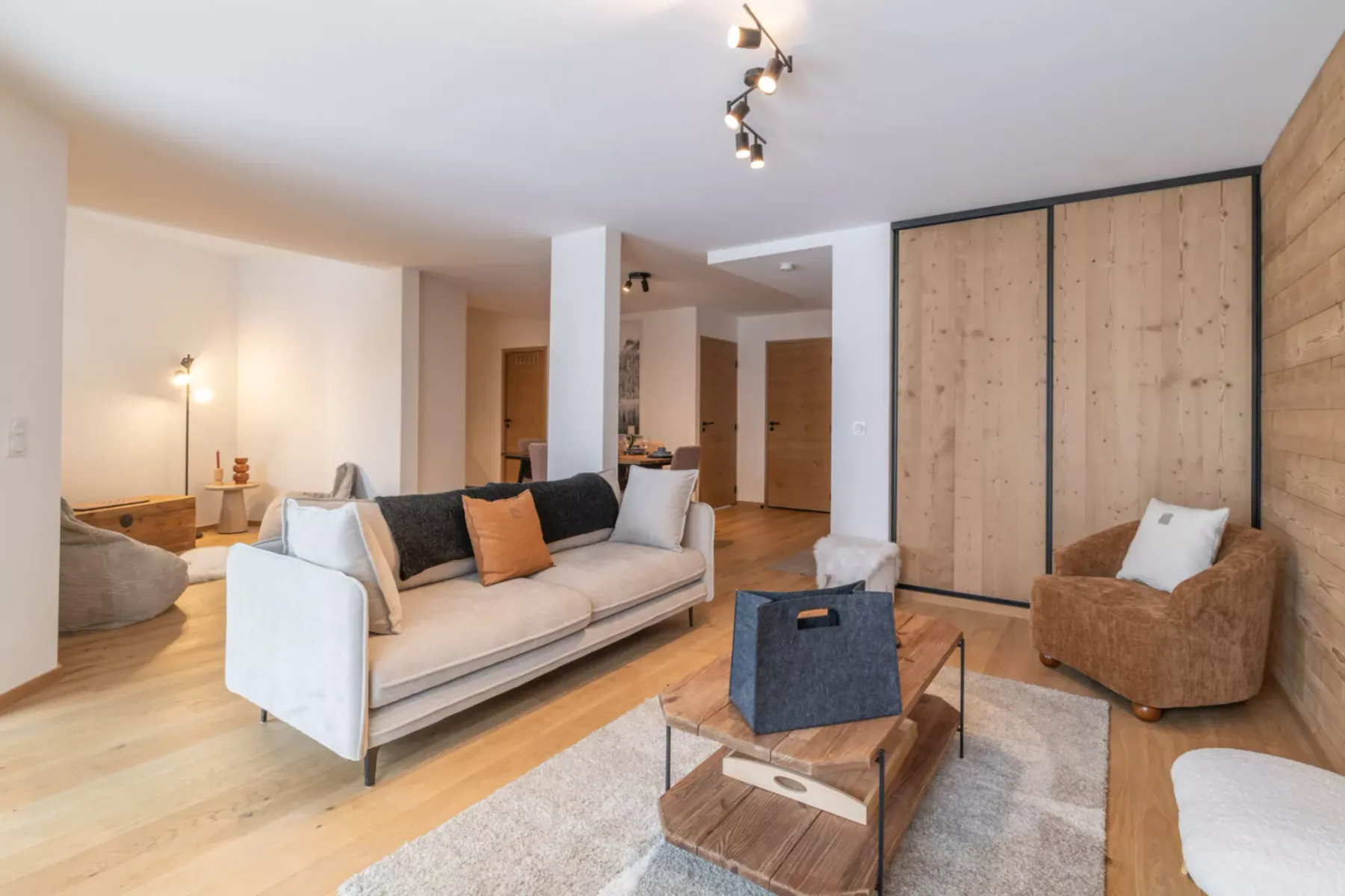 A living room with seating around a low coffee table and a large wooden cabinet.