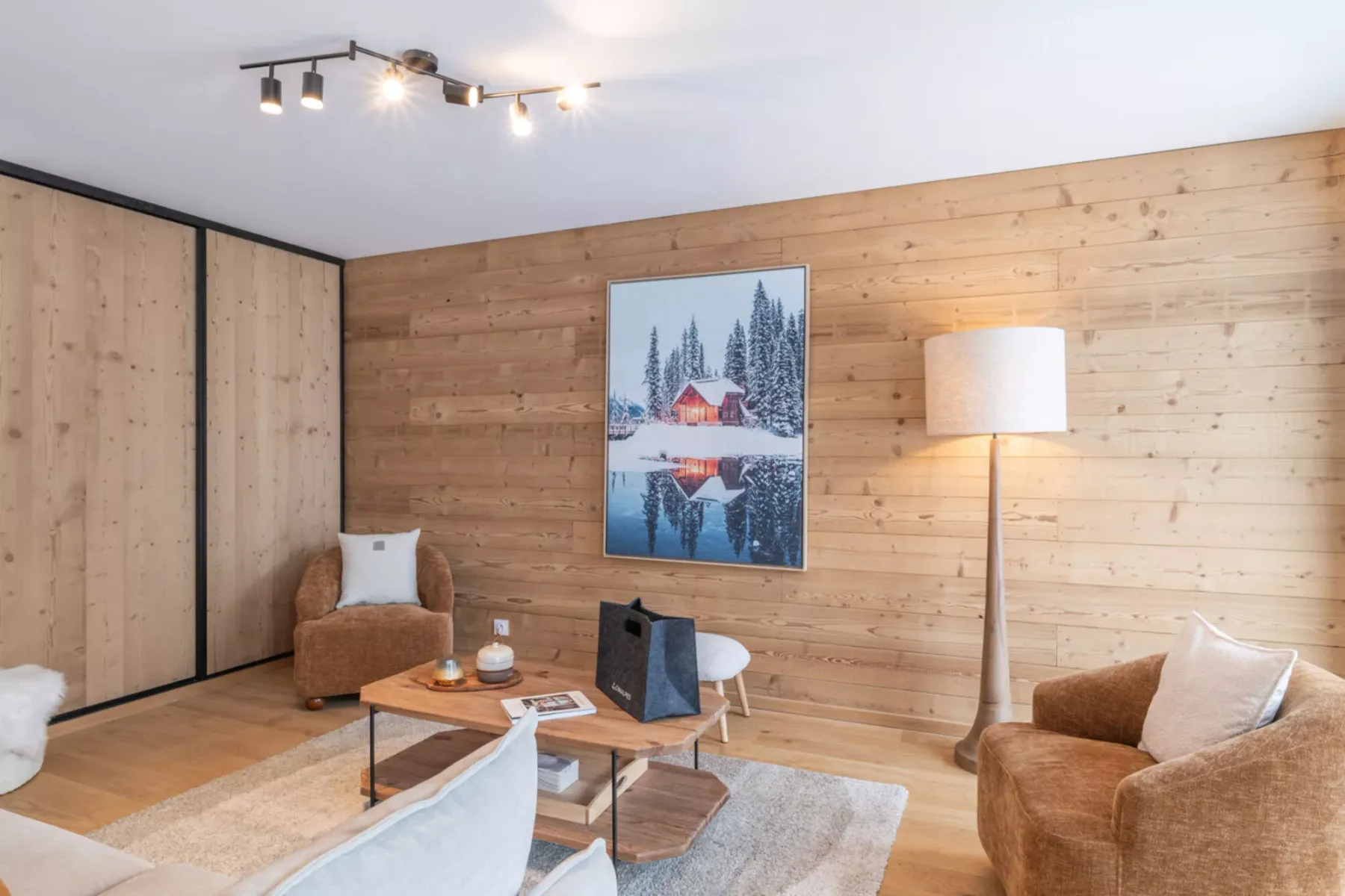 A wood-paneled living room with seating, a coffee table, and a floor lamp.