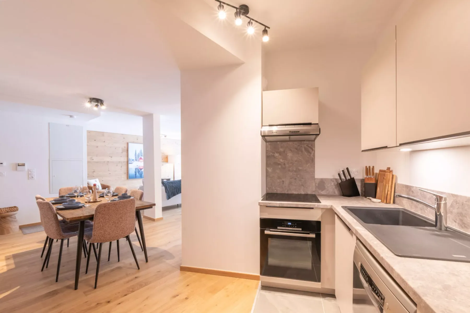 An open-plan kitchen and dining area with a wooden table and countertop.