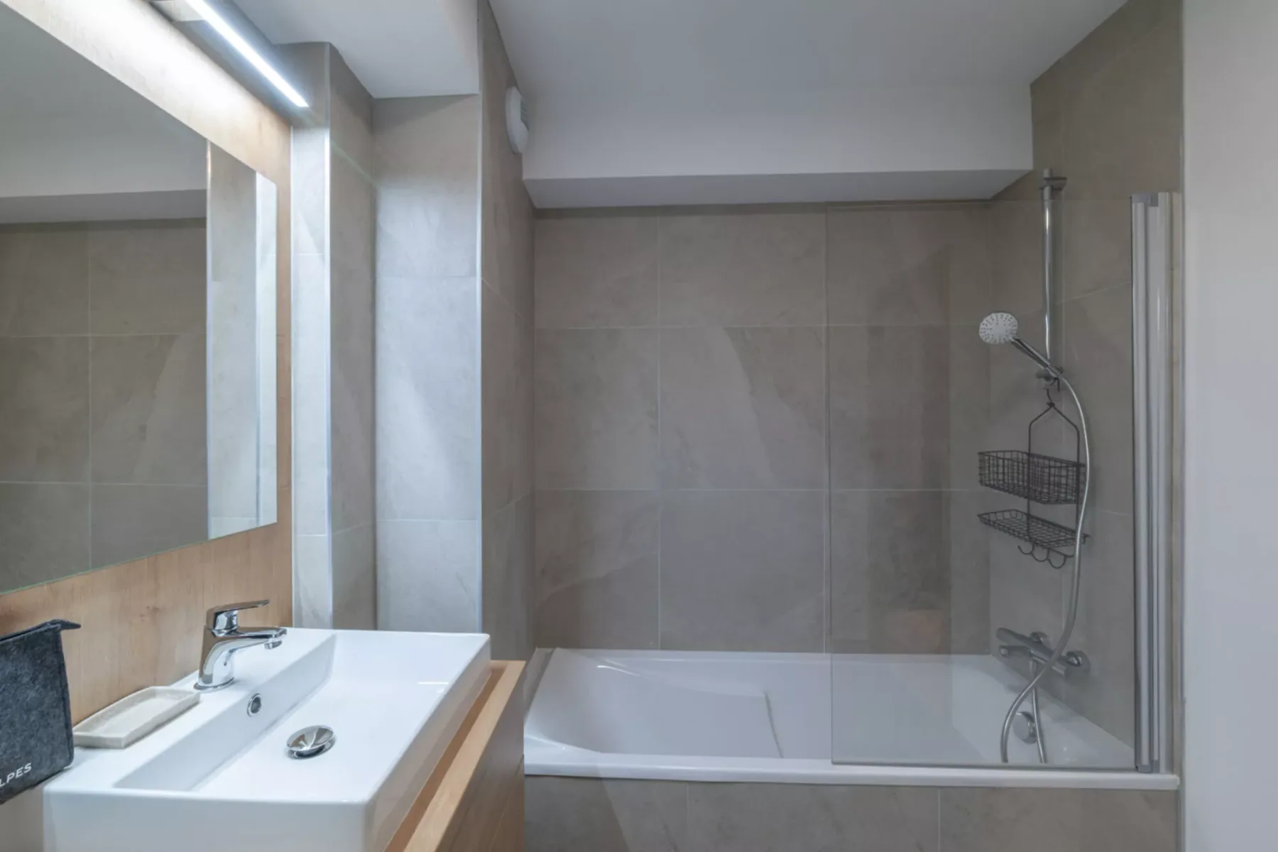 A bathroom with a sink beside a bathtub and shower.