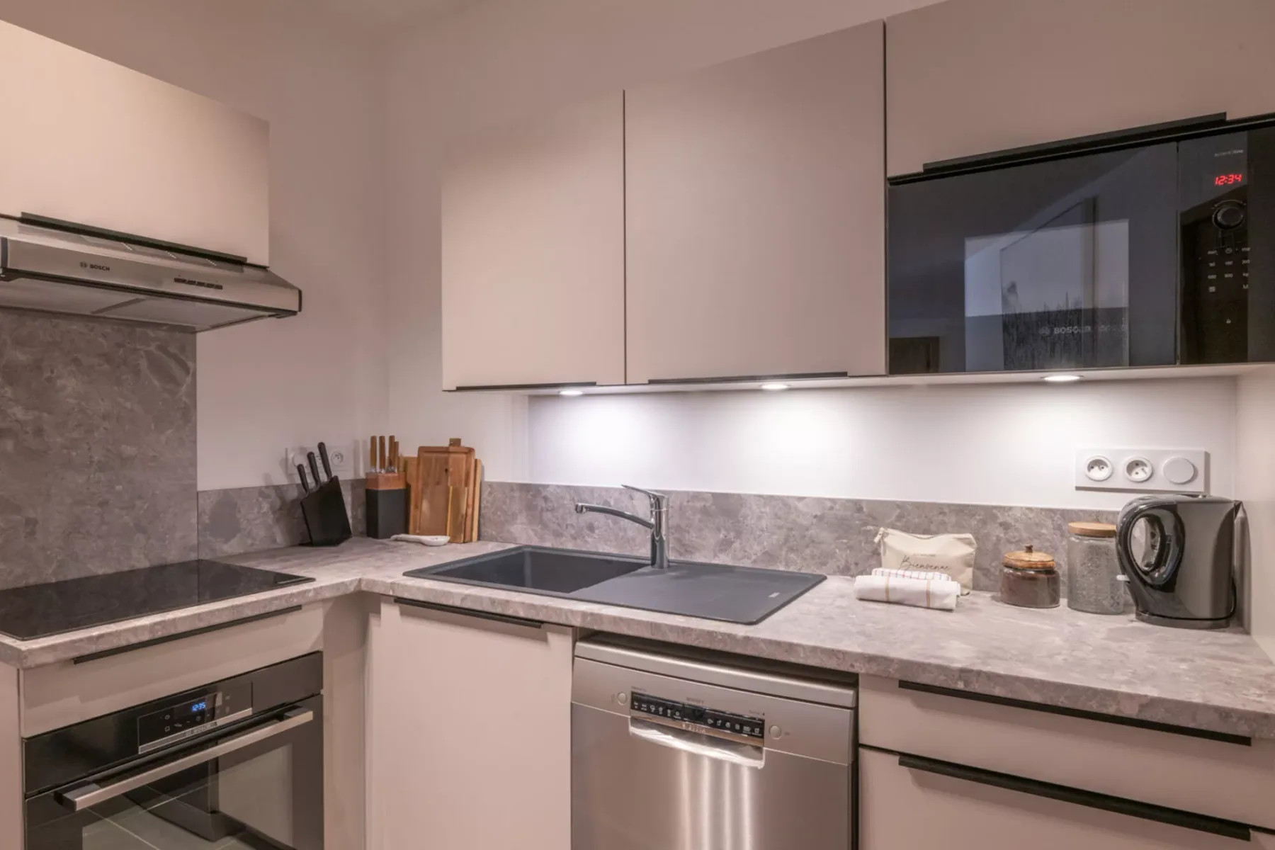 A modern kitchen with a countertop, sink, and built-in appliances.