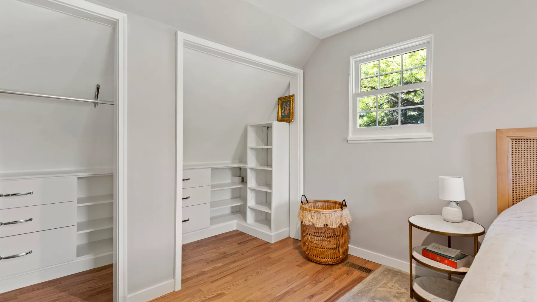 A bedroom with built-in storage, a window, and a bed.