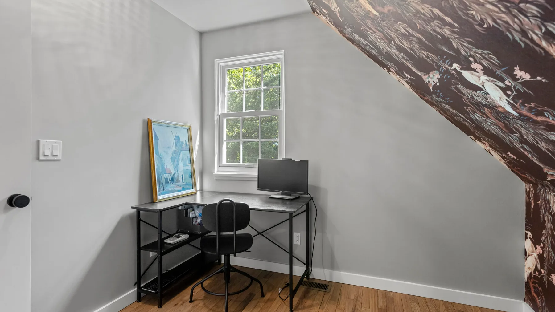 A compact workspace with a desk, chair, and window.