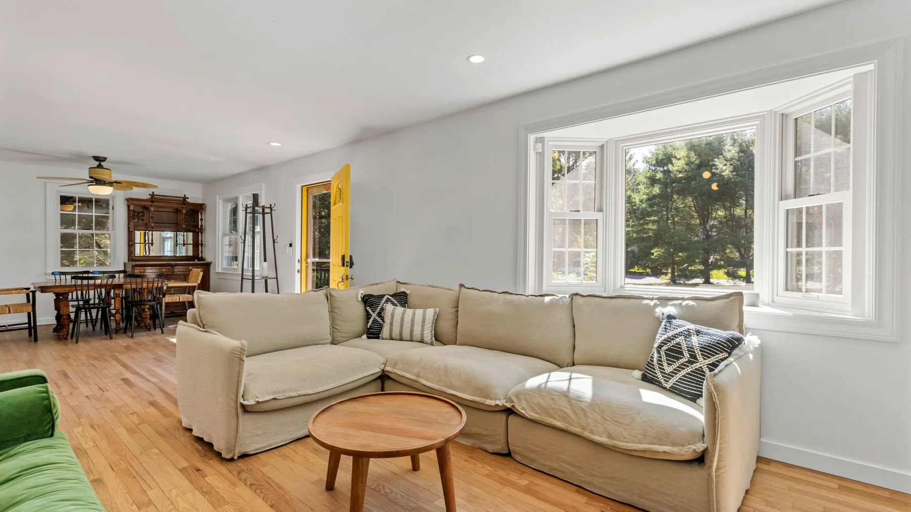Una sala luminosa con una zona de asientos junto a grandes ventanas.