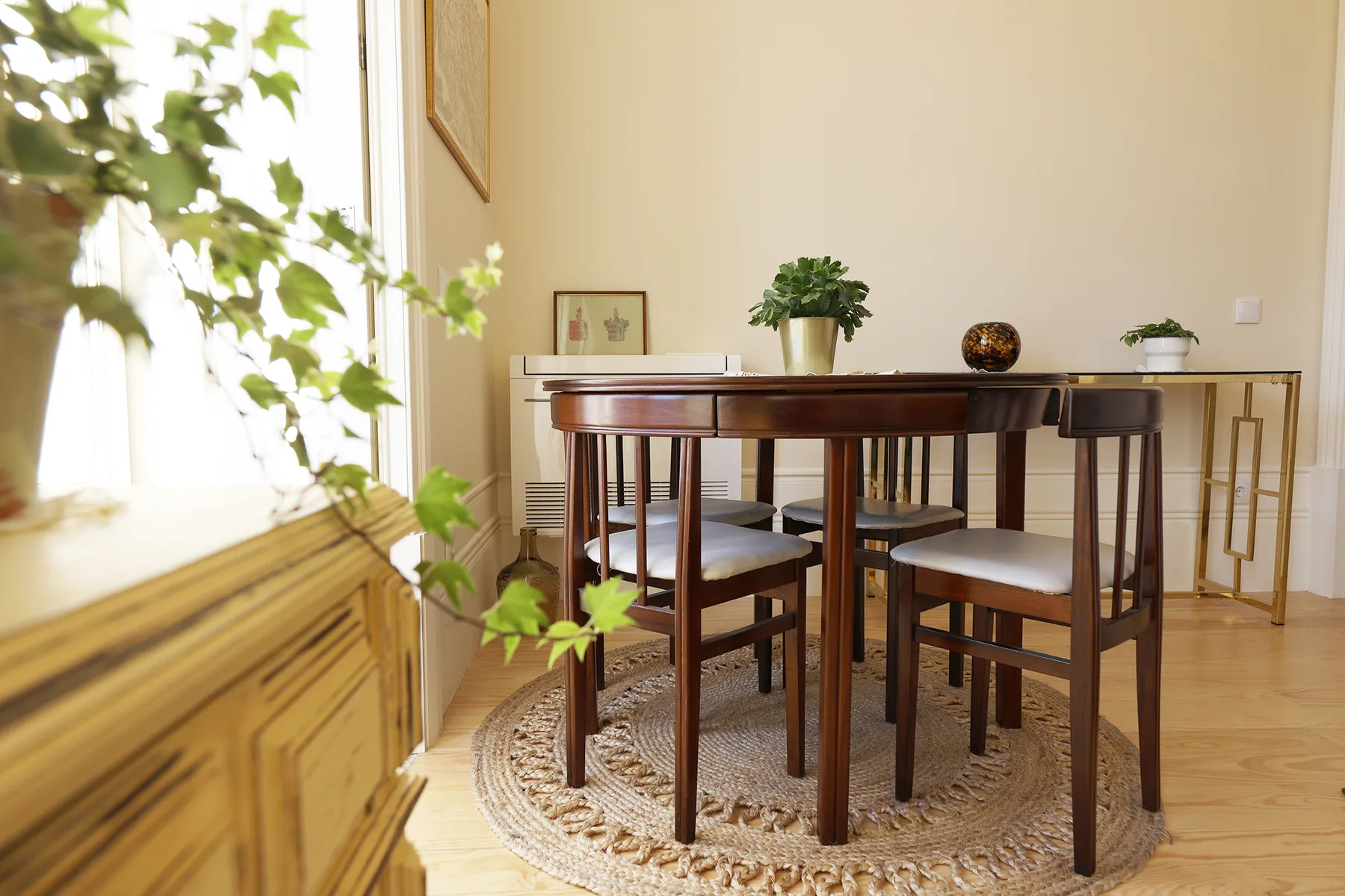 Comedor con una mesa de madera y sillas junto a una ventana luminosa.
