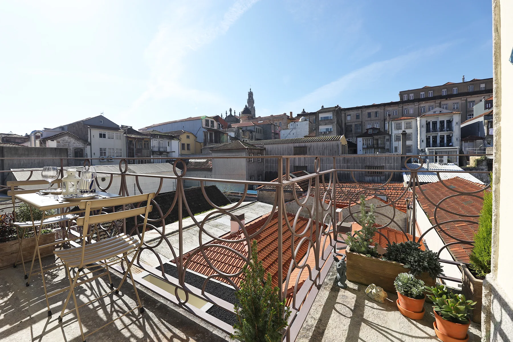 Una terraza en la azotea ofrece vistas de edificios y tejados de tejas rojas.