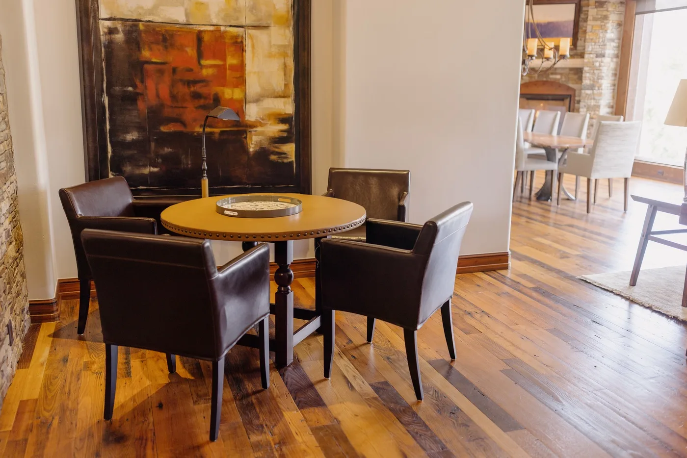A dining area with a round table and dark upholstered seating.