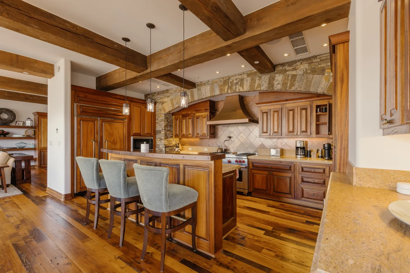 A spacious kitchen with wooden cabinetry, a central island, and bar seating.