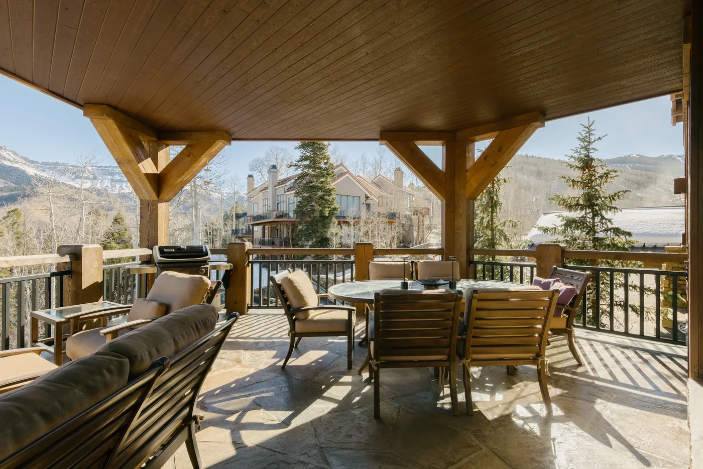 A covered outdoor terrace with seating and mountain views.