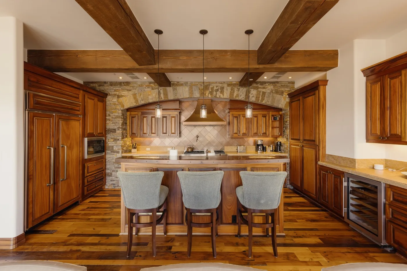 A spacious kitchen with wooden cabinetry, a central island, and pendant lights.