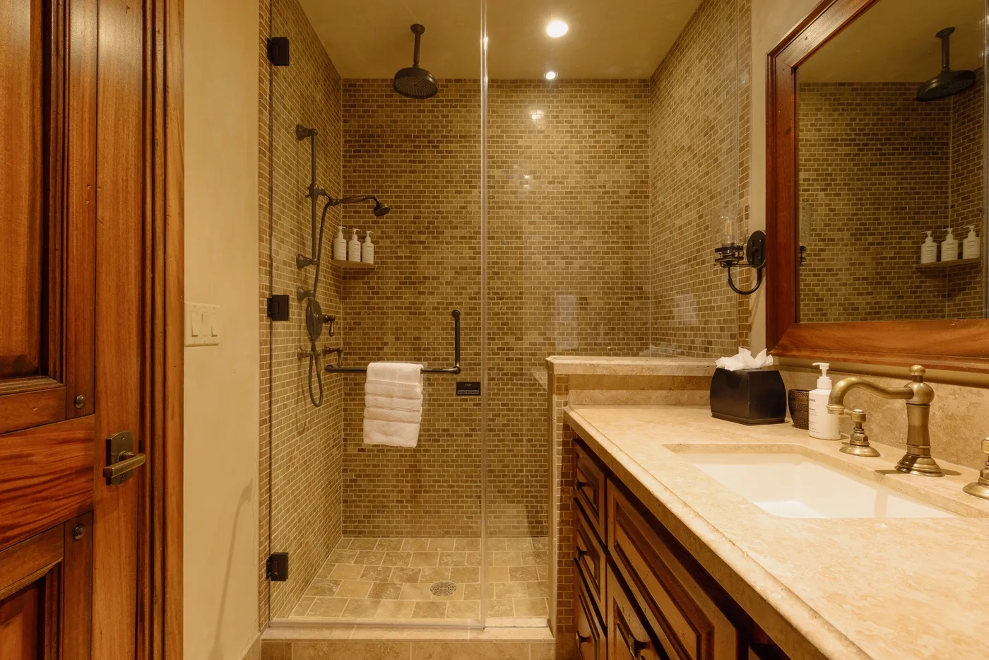 A bathroom with a tiled shower and a sink vanity.
