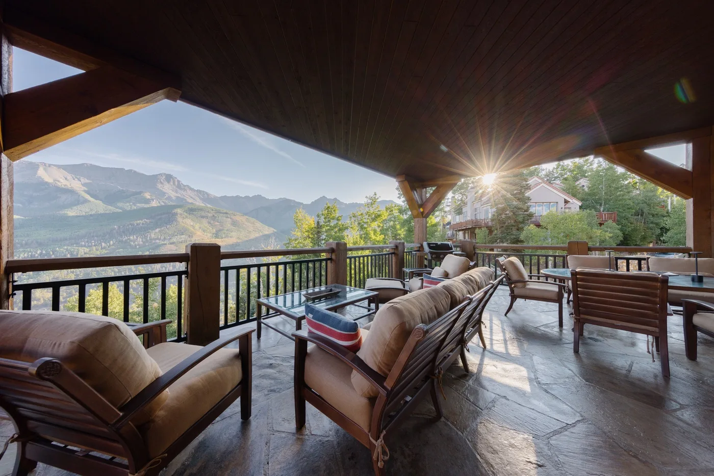 A covered outdoor seating area overlooks a mountain landscape.