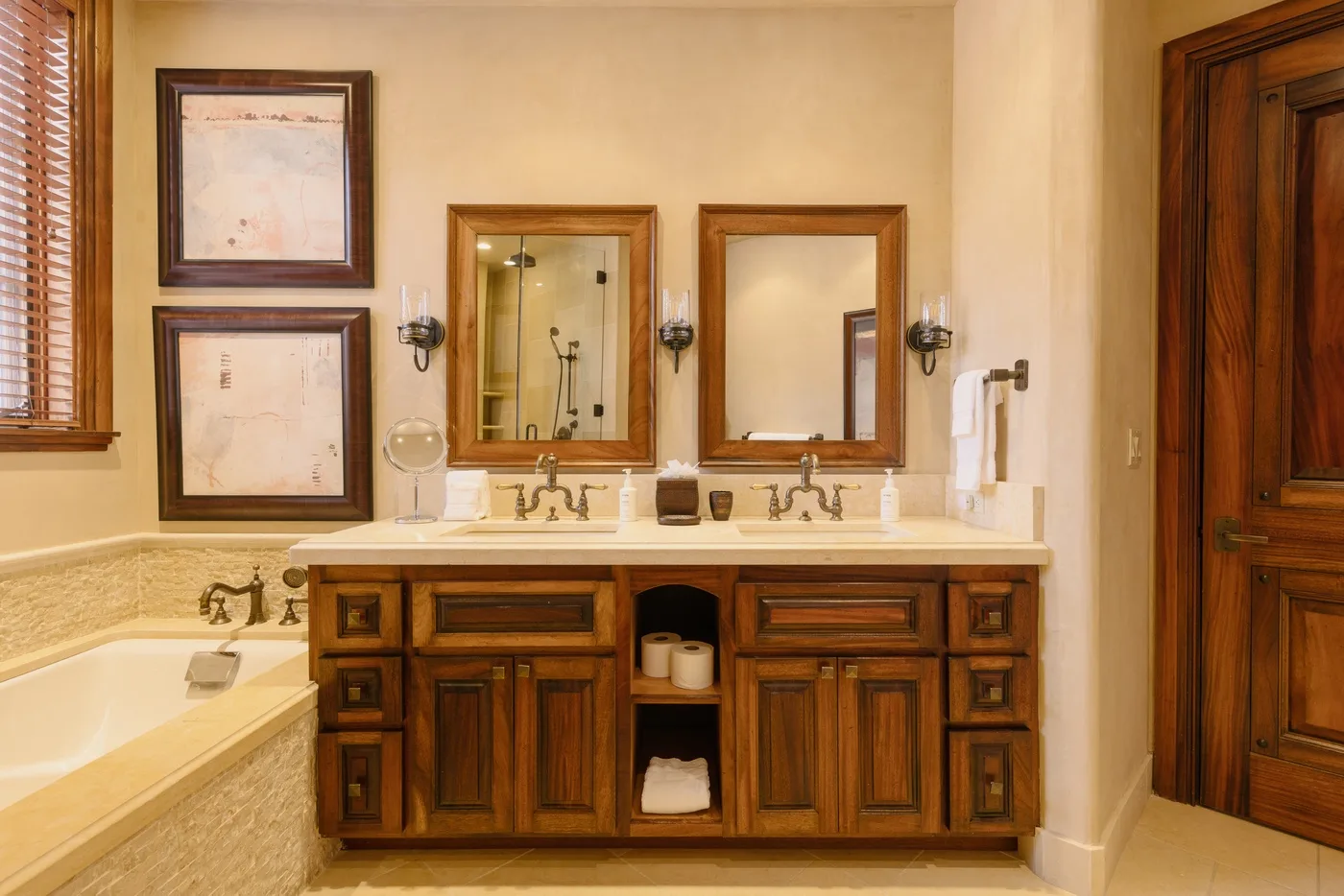 A bathroom vanity with two sinks and mirrors sits beside a bathtub.