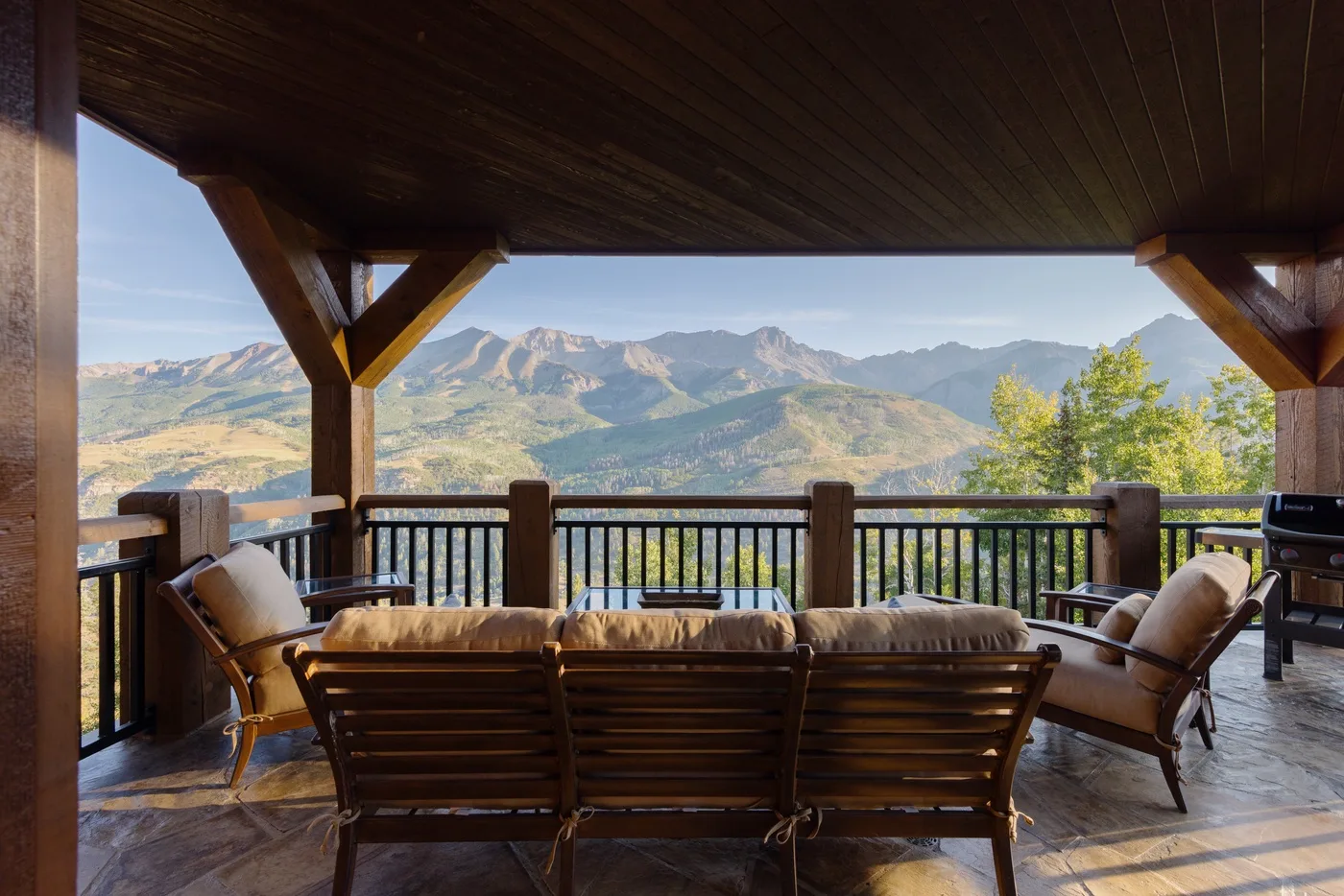 A covered outdoor seating area overlooks a mountain landscape.