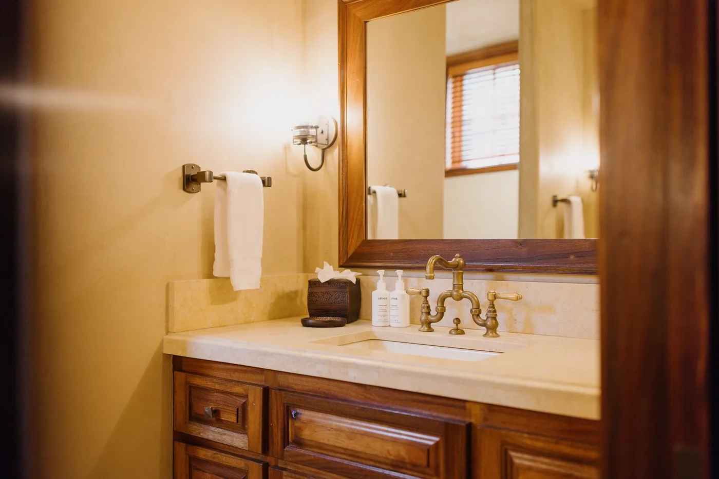 A bathroom vanity with a sink, mirror, and folded towels.