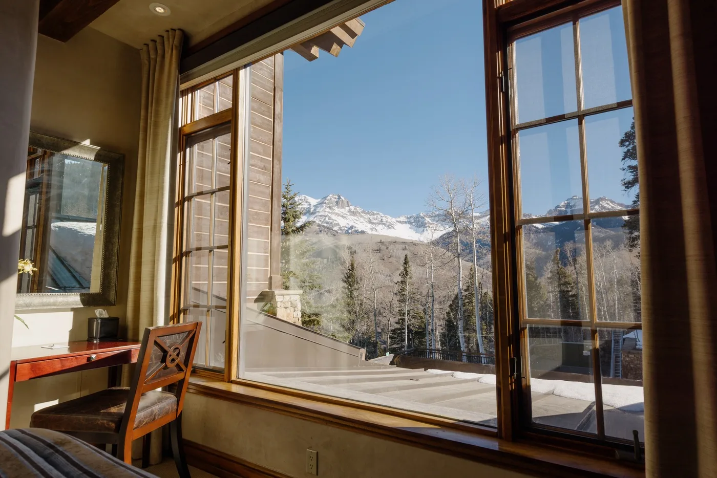 A bright interior with large windows overlooking a mountain landscape.