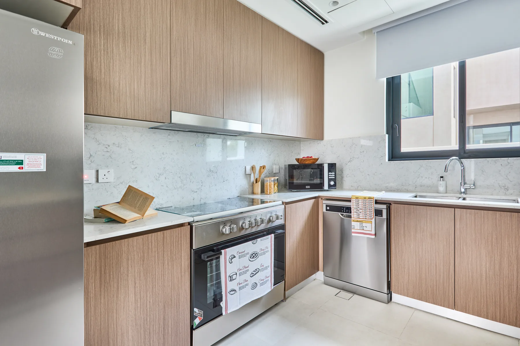 Una cocina moderna con gabinetes de madera, electrodomésticos de acero inoxidable y una ventana.