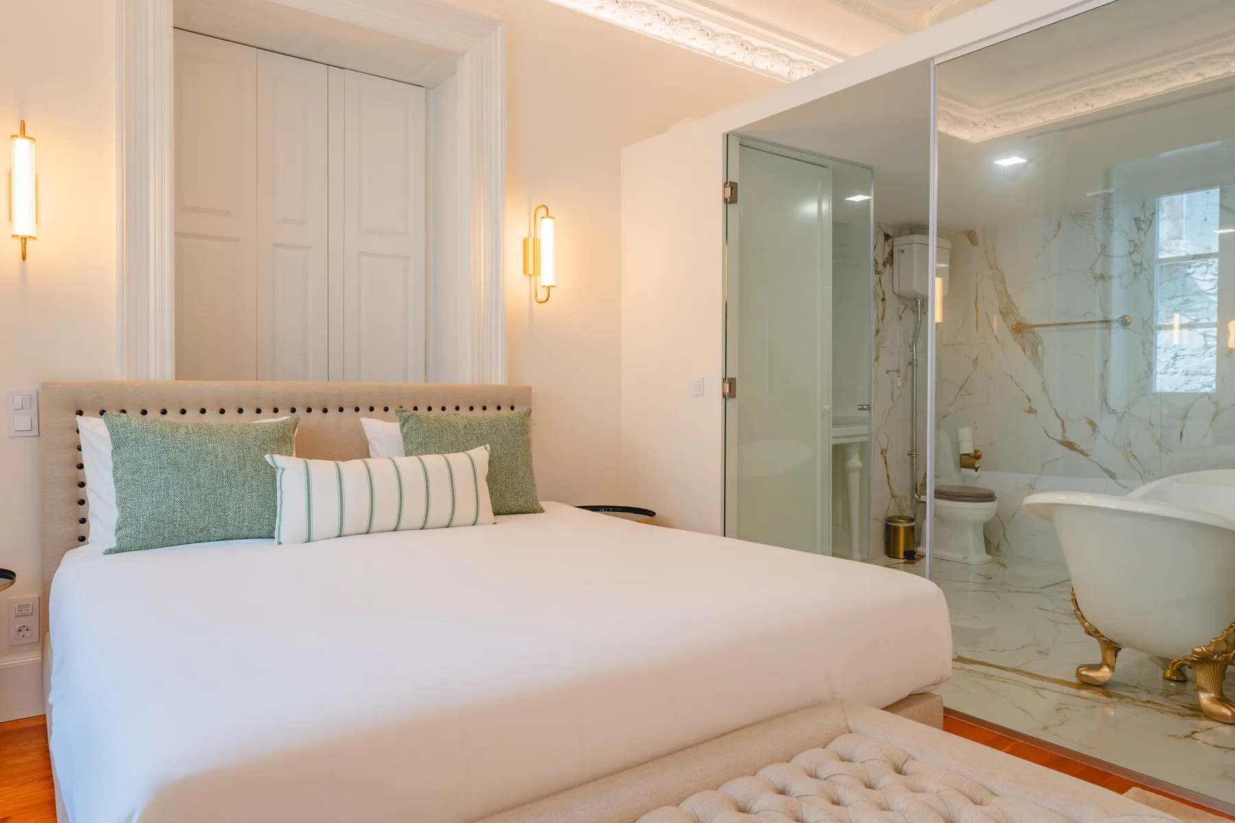 Un dormitorio con una cama grande junto a un baño abierto.