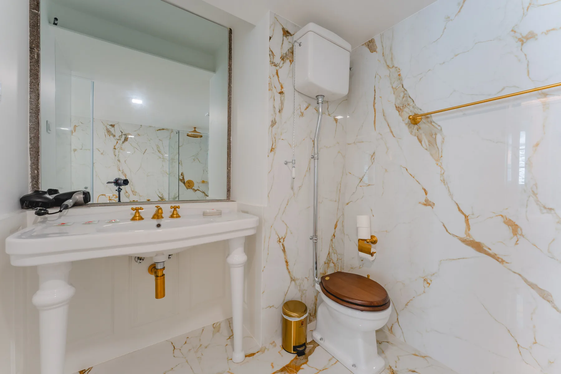 Un baño con lavabo, espejo e inodoro.