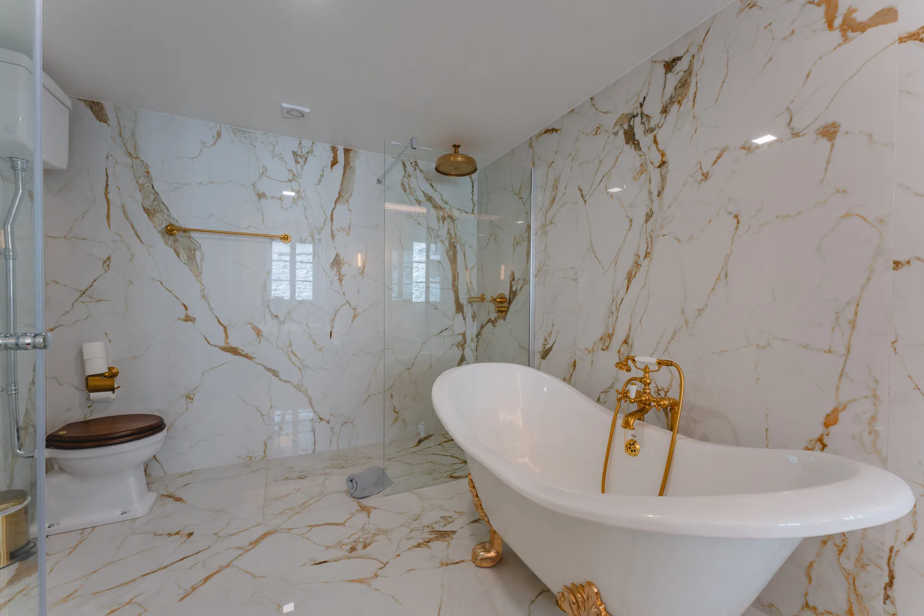 Un baño con una bañera exenta y paredes con vetas decorativas.