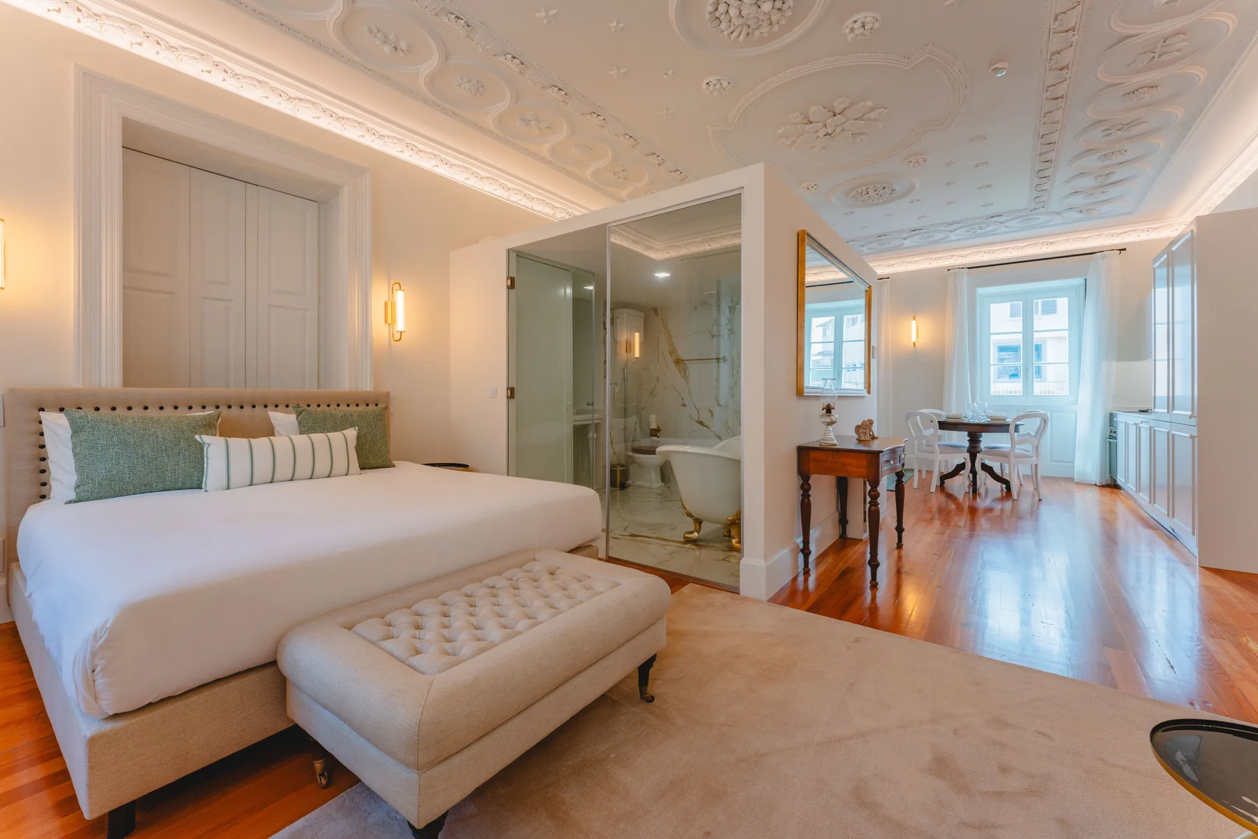 Un dormitorio con una cama grande y una zona de baño abierta.