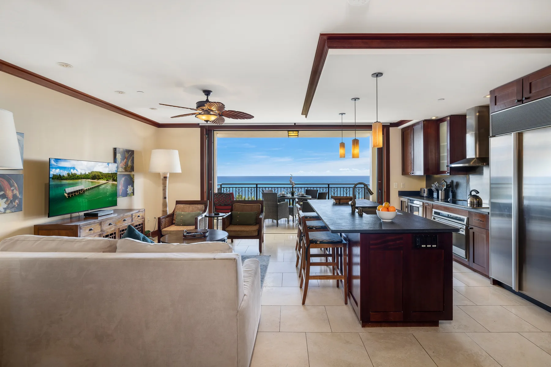 Una sala de estar y cocina abiertas, con una isla de comedor y vista al mar.