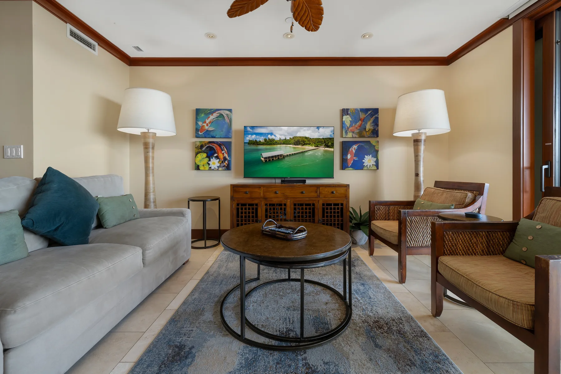 Una sala de estar con asientos alrededor de una mesa de centro y un televisor.