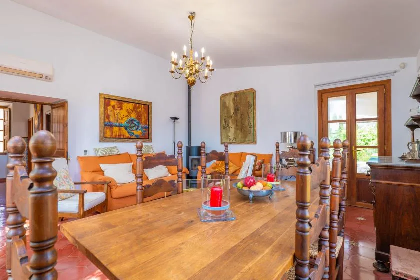 A dining room with a long wooden table and orange seating.