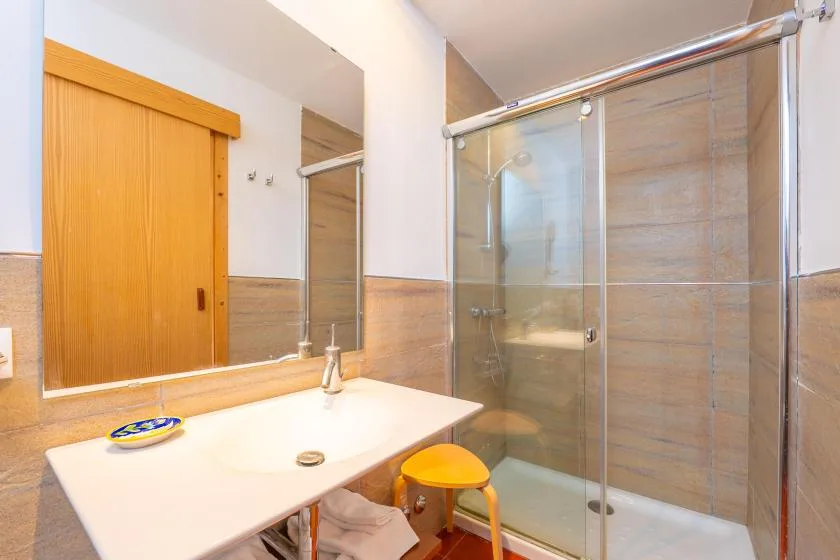 A bathroom with a sink, mirror, and glass shower.