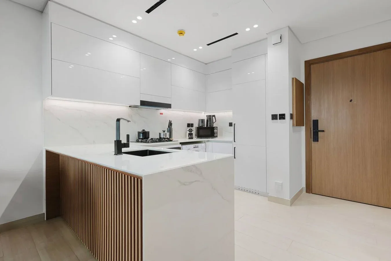 Una cocina moderna y luminosa con gabinetes blancos e isla central.