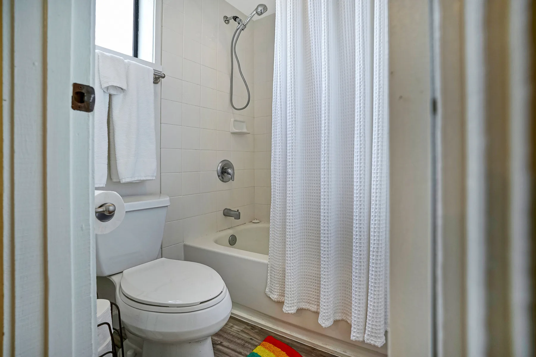A bathroom with a toilet, bathtub, and shower curtain.
