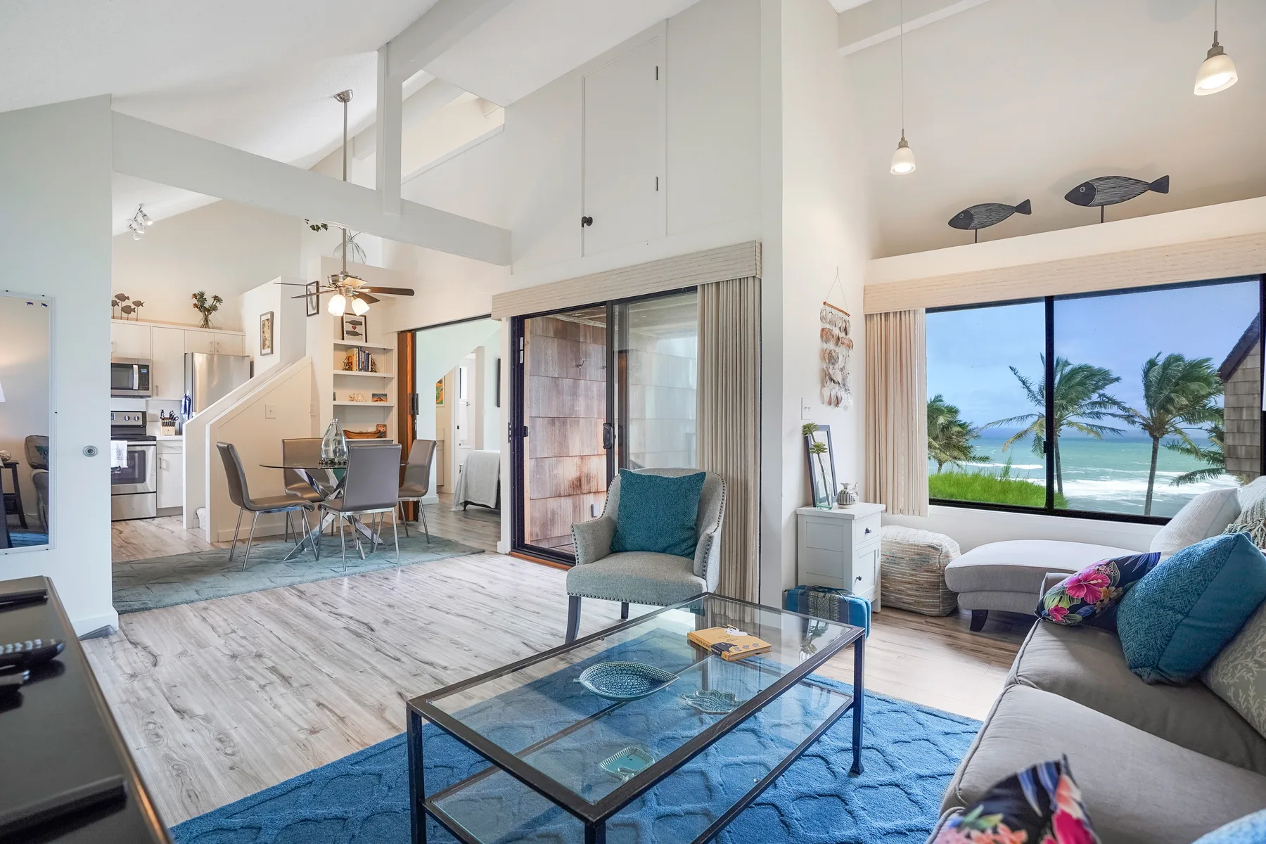 A bright open-plan living and dining area with seating beside a large window.