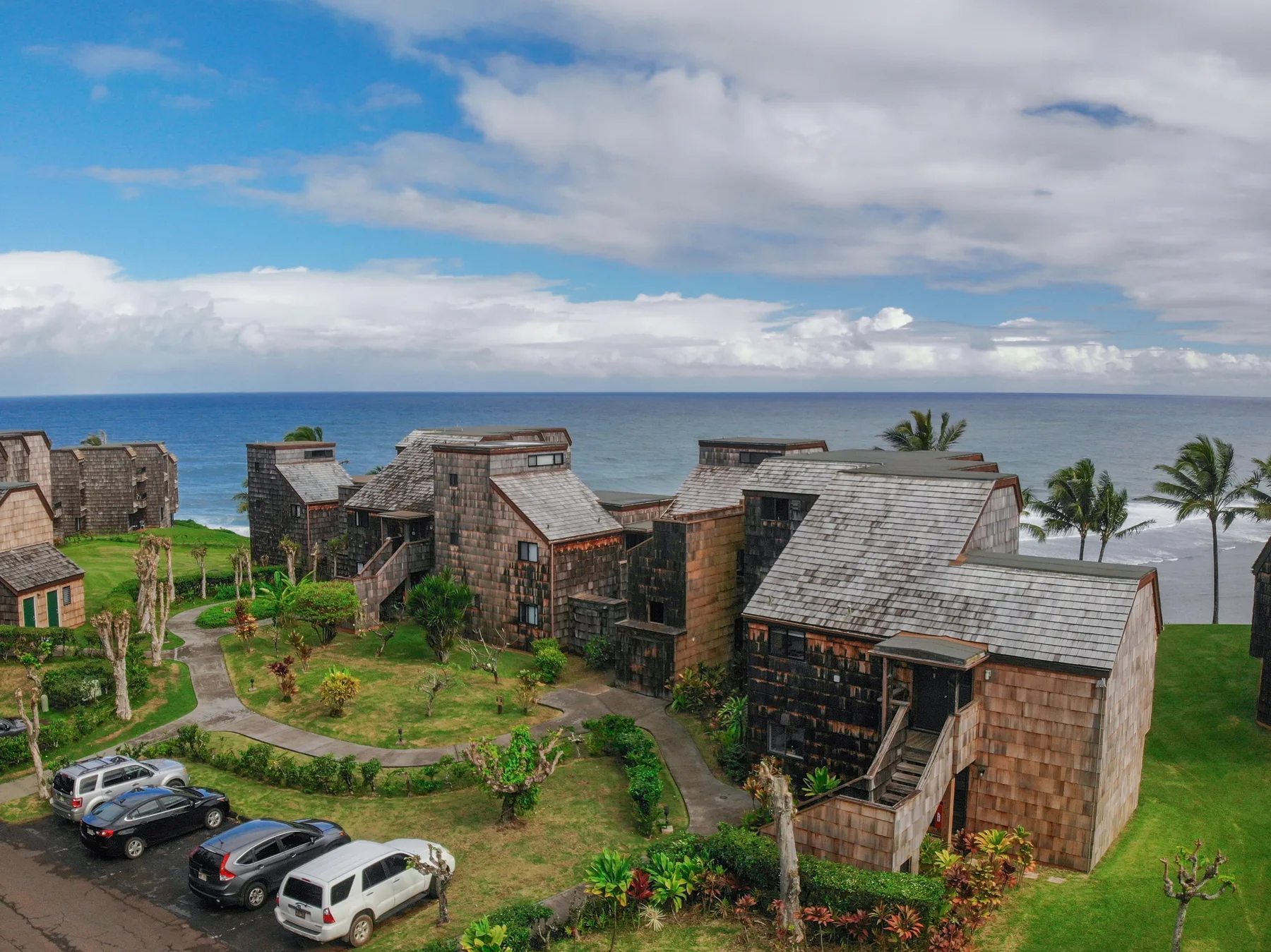 A coastal resort with clustered buildings, landscaped grounds, and the ocean beyond.