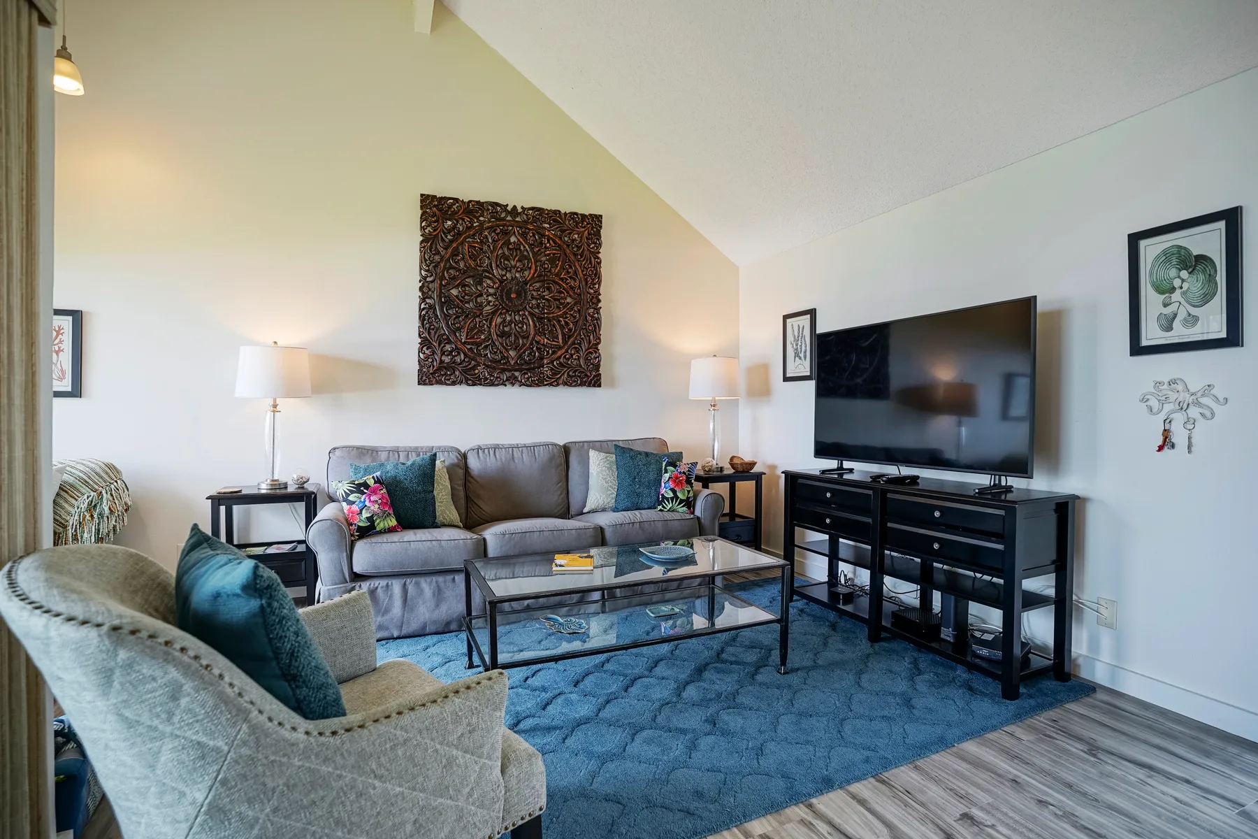 A living room with seating around a coffee table and a television.