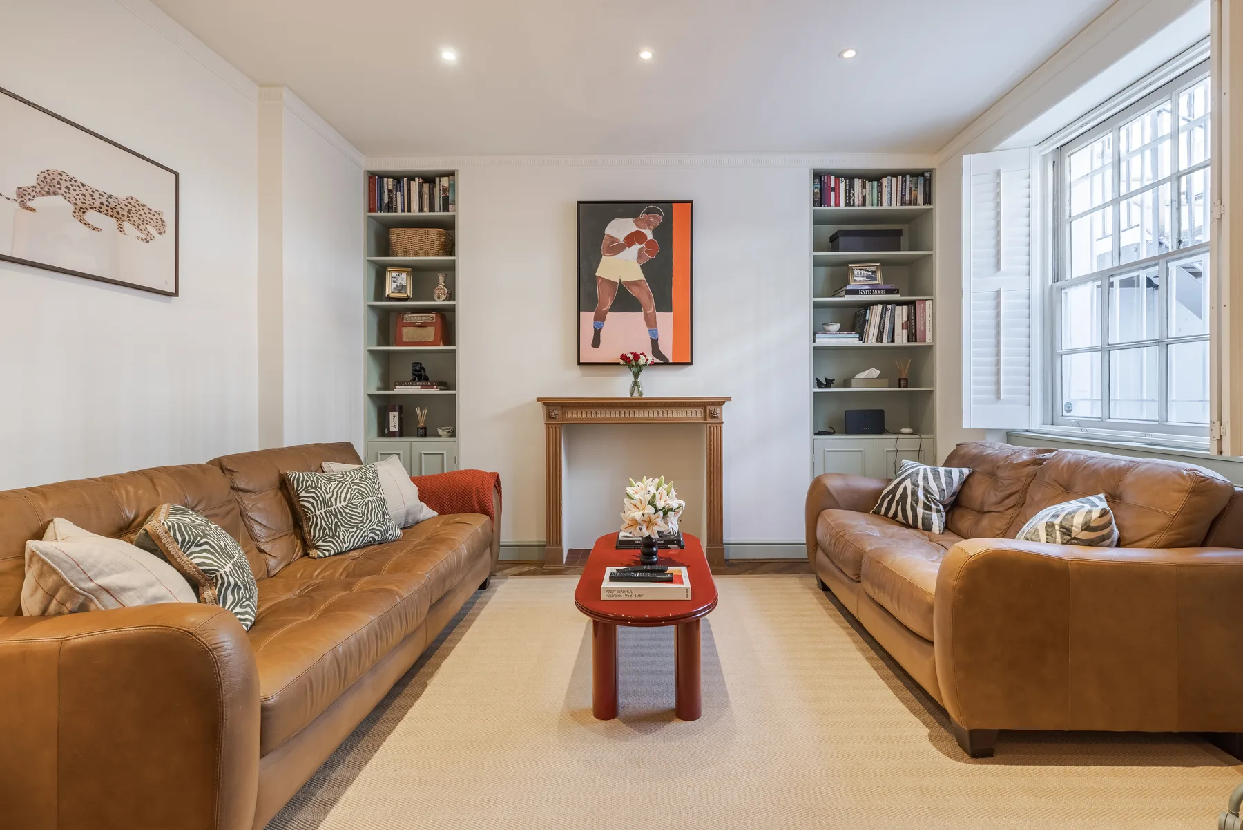 A bright living room with seating arranged around a coffee table and fireplace.