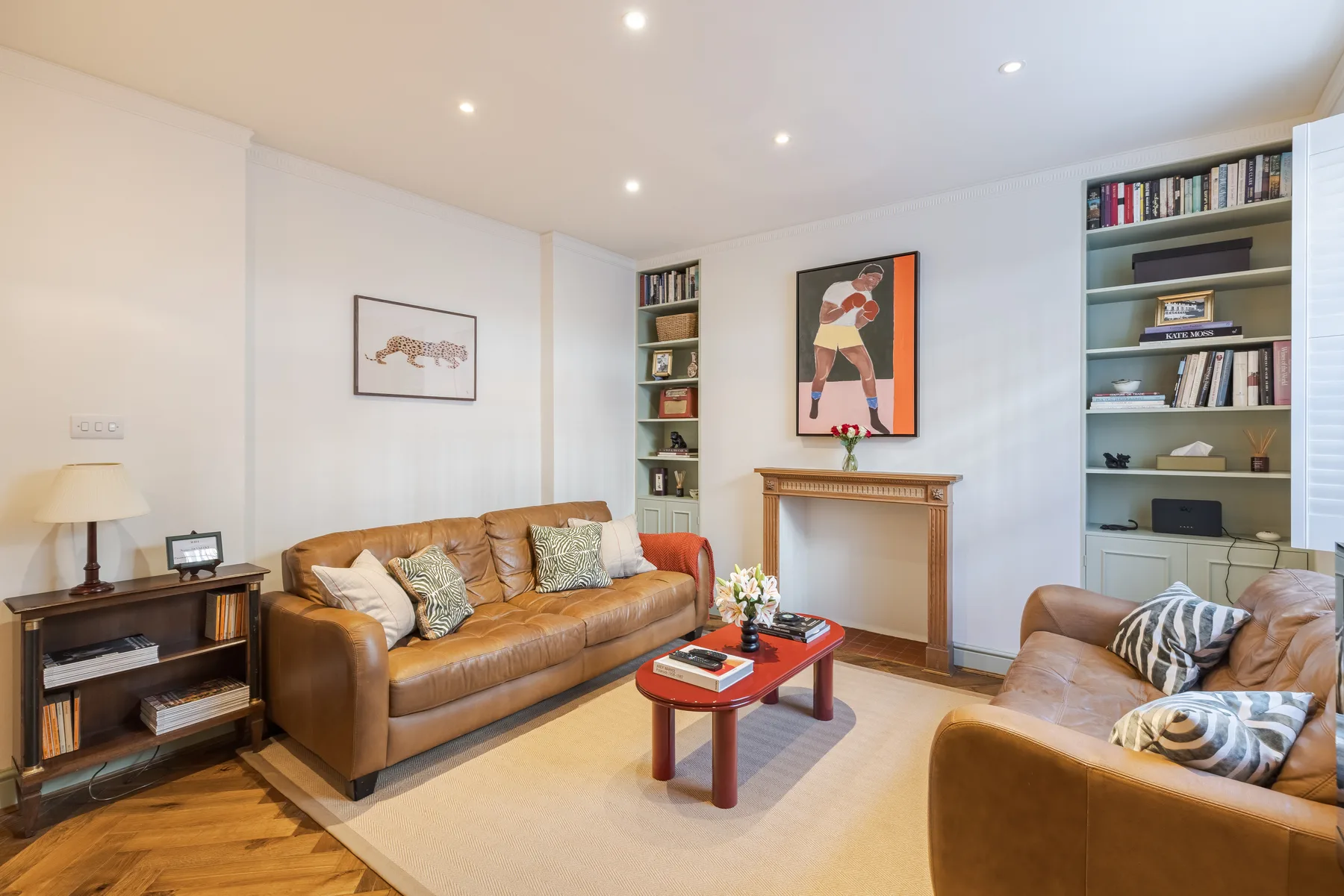 A living room with seating, a coffee table, and bookshelves.