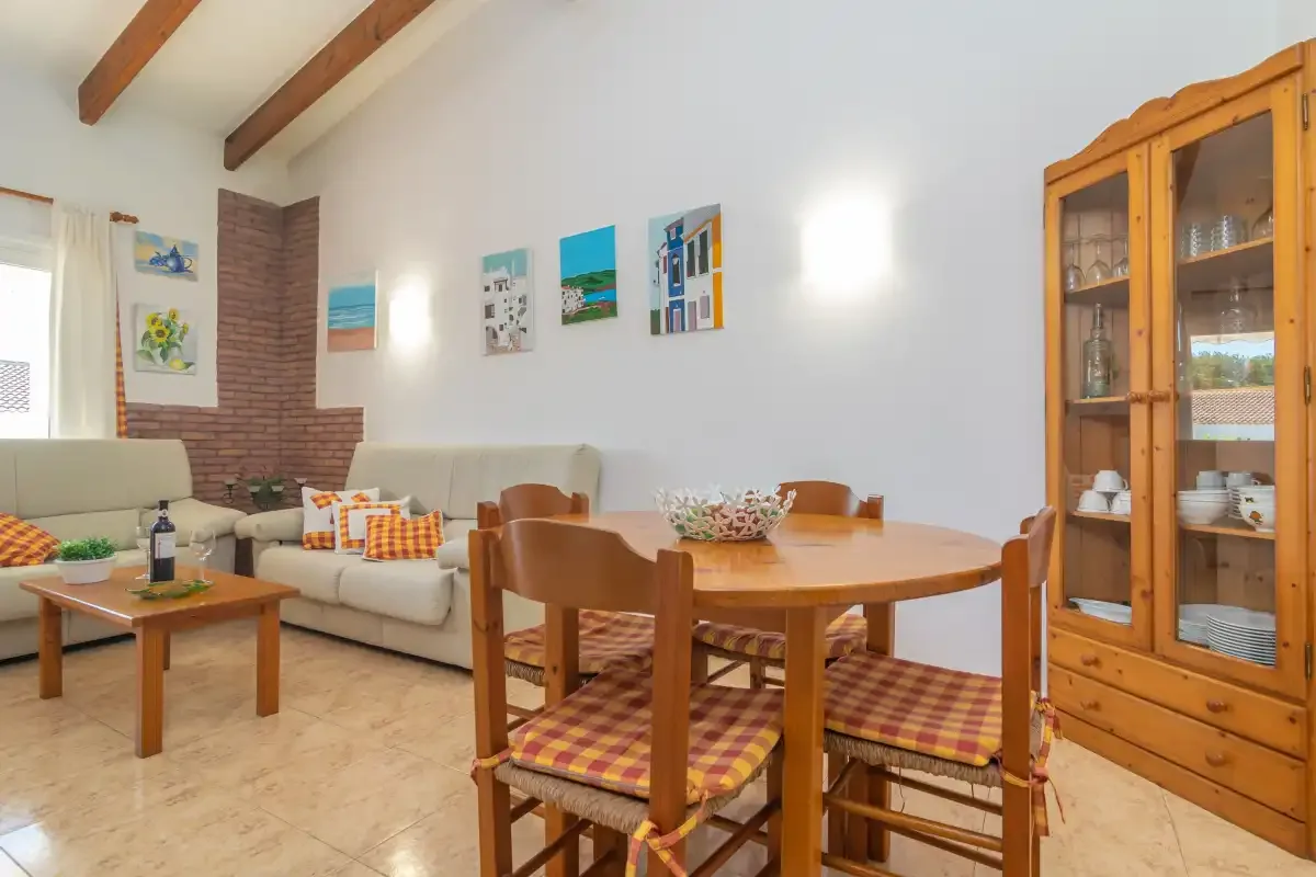 A living and dining room with wooden seating and a glass-front cabinet.