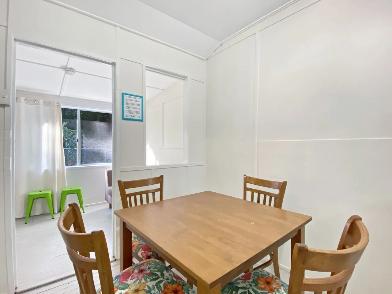Comedor con una mesa de madera y sillas junto a una ventana luminosa.