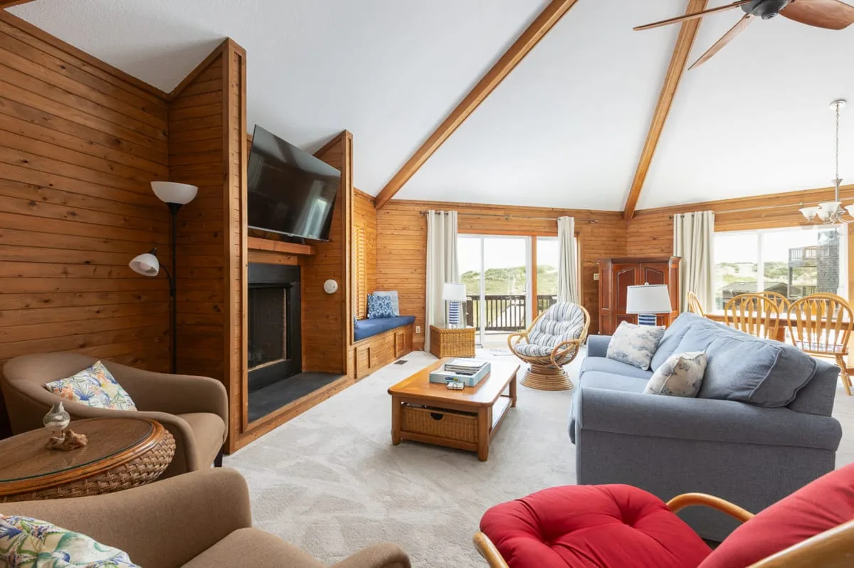 A wood-paneled living room with seating, a coffee table, and large windows.
