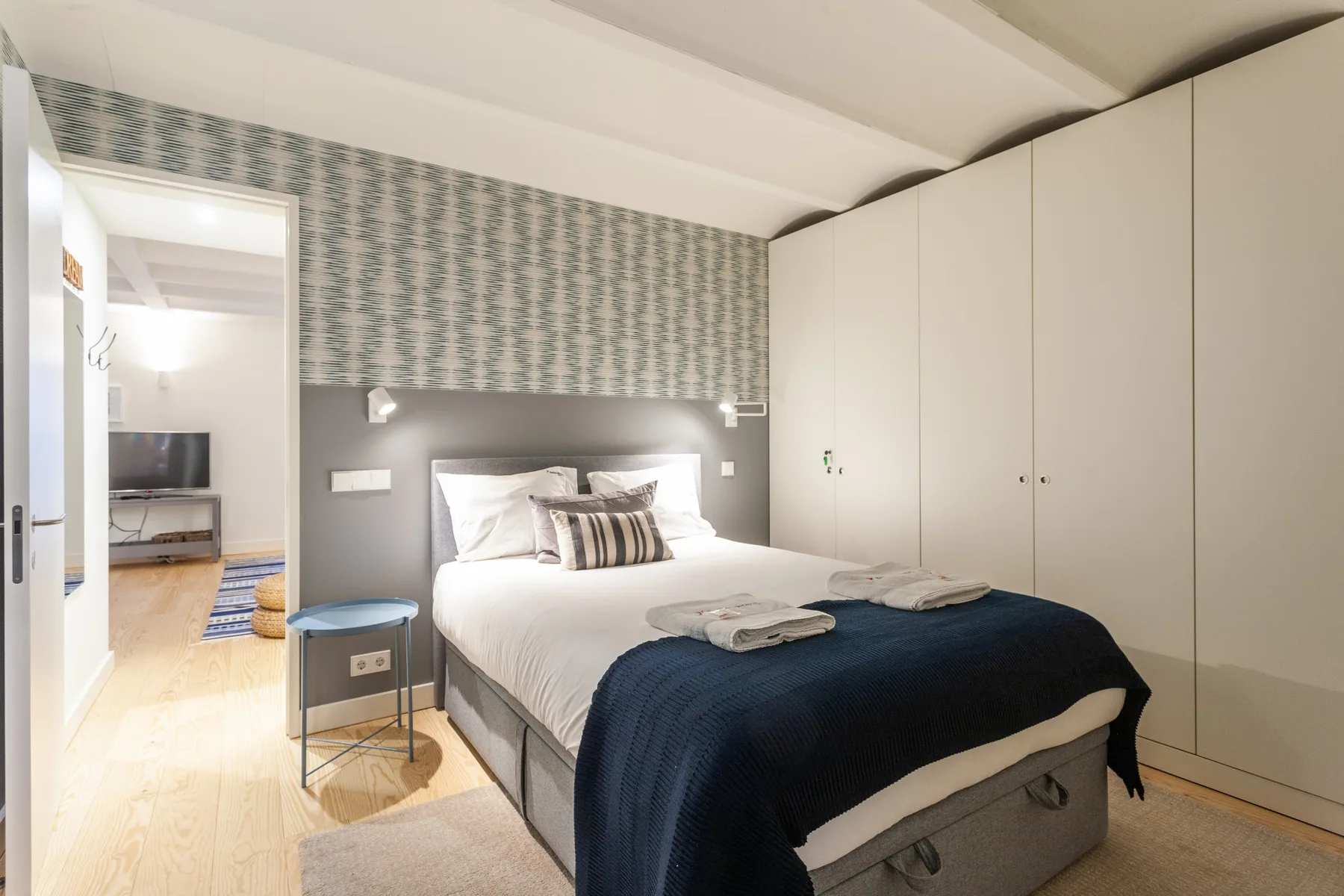 Un dormitorio con una cama, una mesita de noche y armarios empotrados.