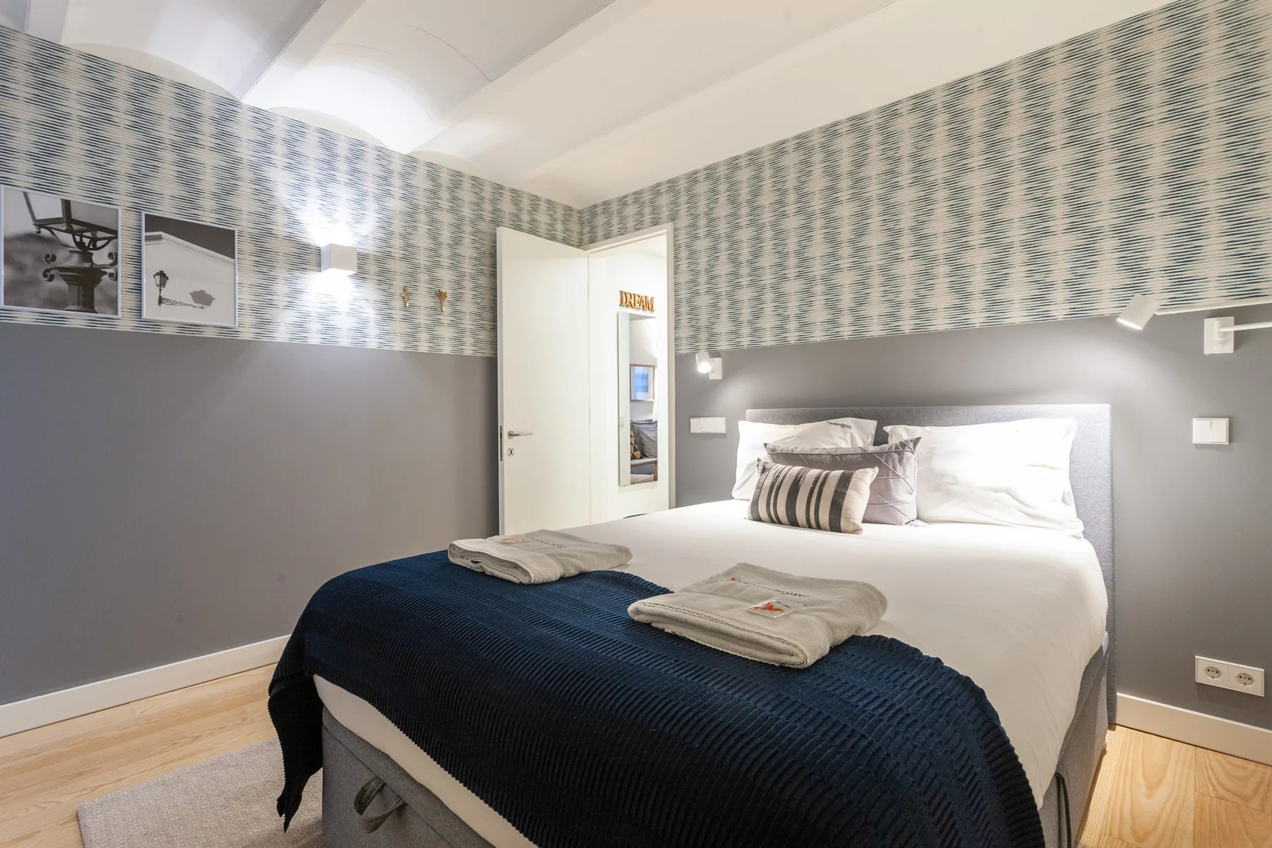 Dormitorio con una cama bien arreglada y toallas dobladas.
