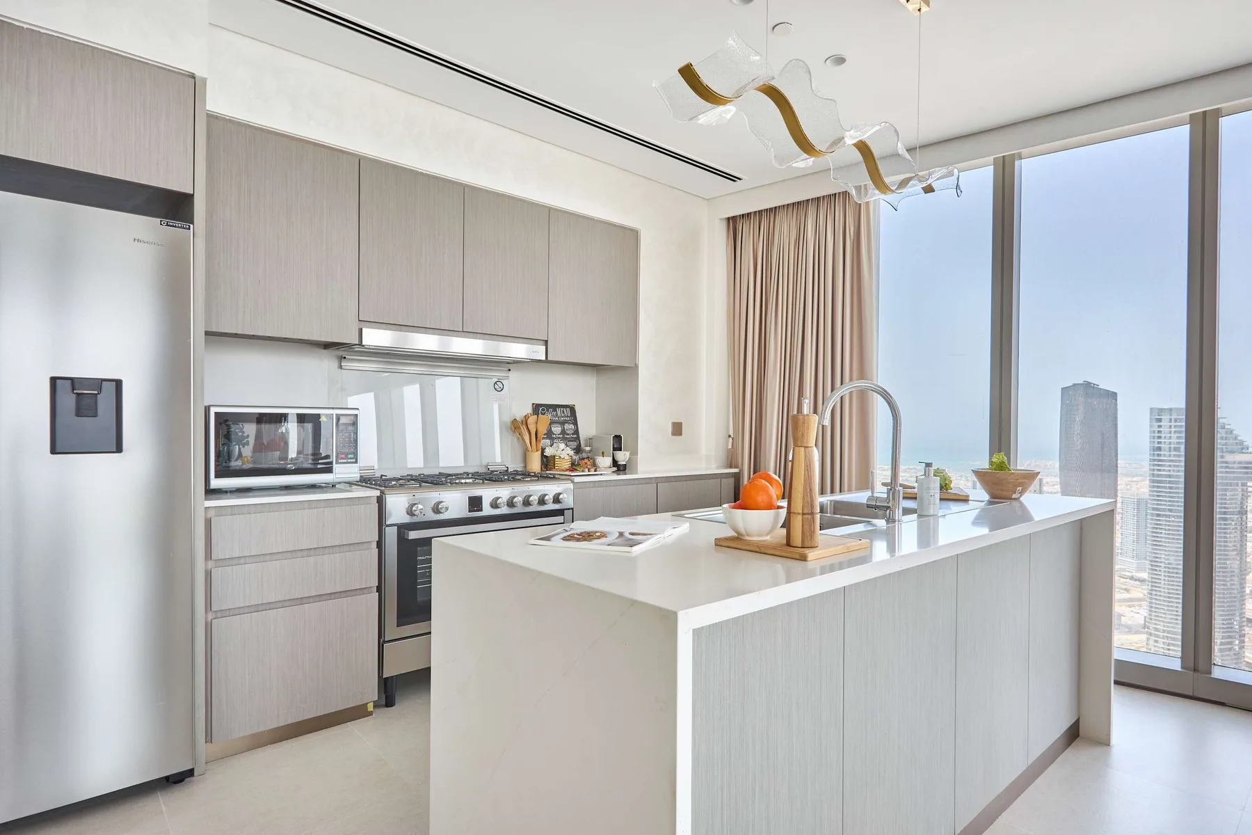 Una cocina moderna y luminosa con una gran isla y ventanales de piso a techo.