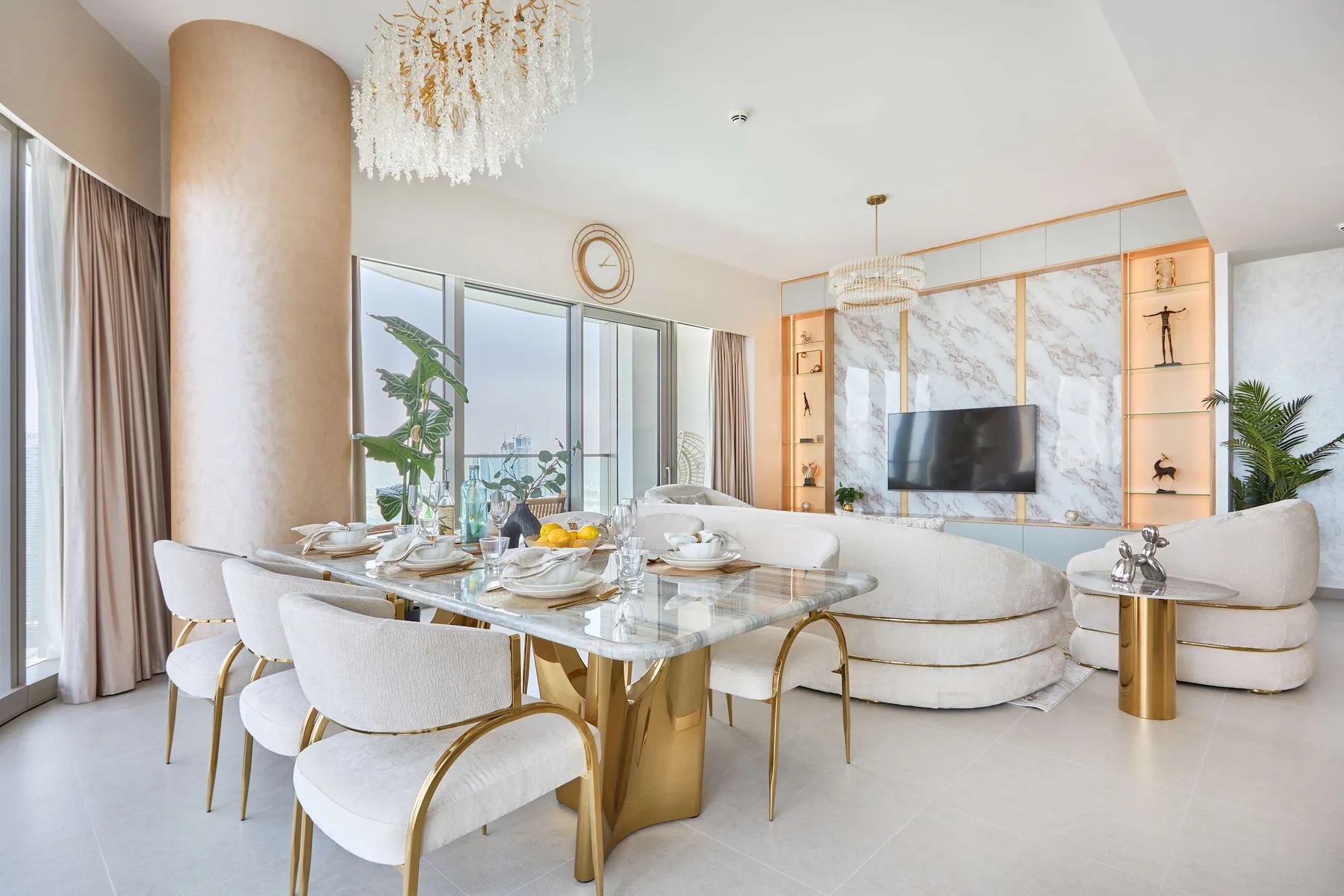 Una luminosa zona de comedor y sala cuenta con una mesa de vidrio y un televisor.