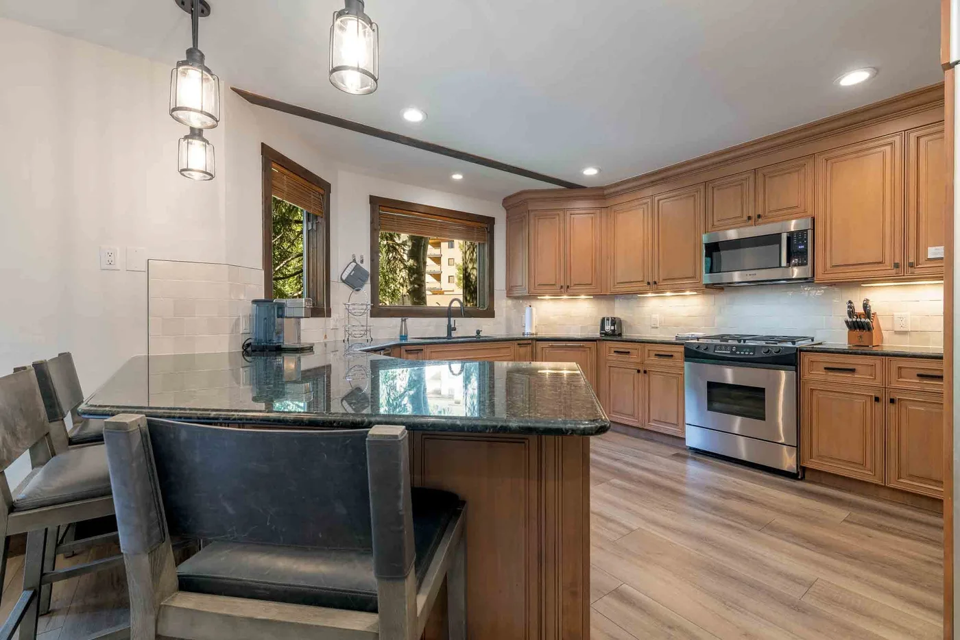 A kitchen with wood cabinetry, stainless steel appliances, and a central island.