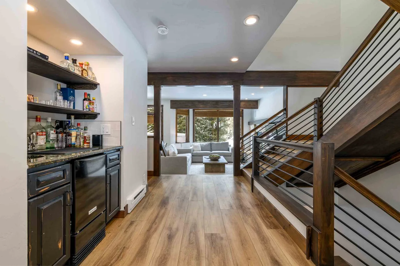 A modern open-plan living area with a kitchenette and staircase.