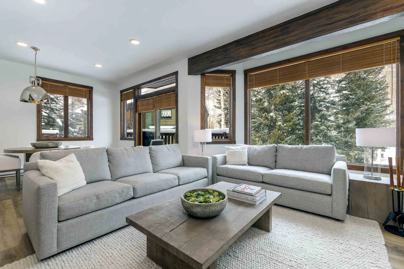 A bright living room with gray seating arranged around a low coffee table.