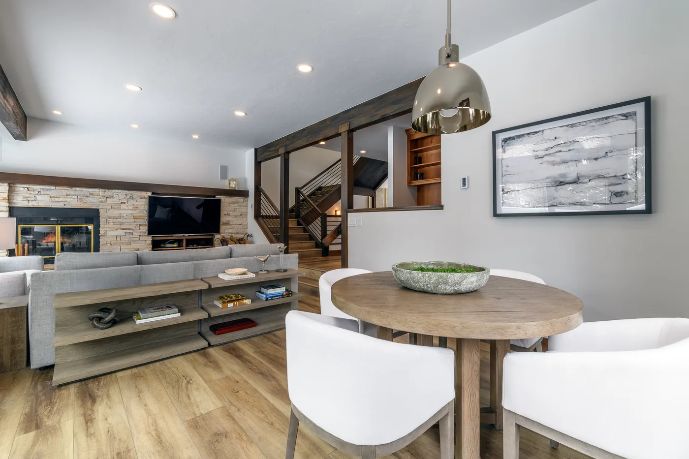 An open-plan living and dining area with a round table and seating.