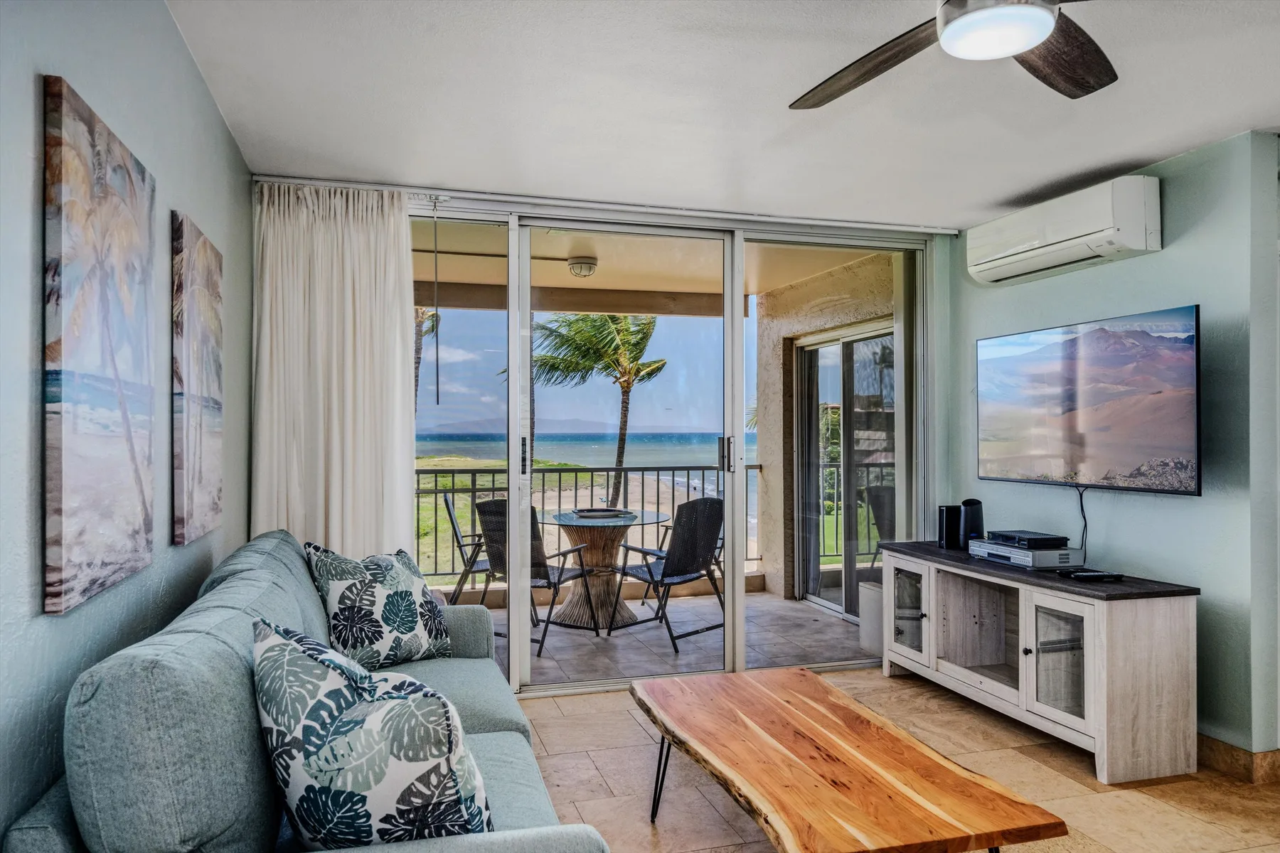 Una sala de estar da a un balcón con vistas al mar.