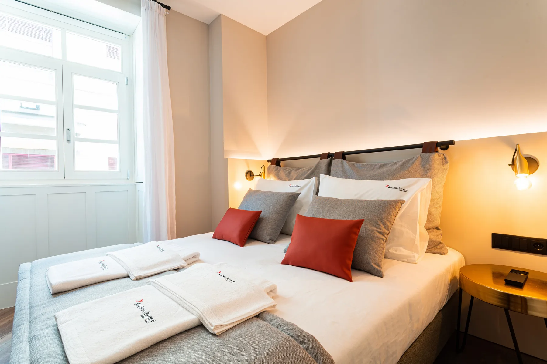 Un dormitorio con una cama bien tendida y toallas dobladas.