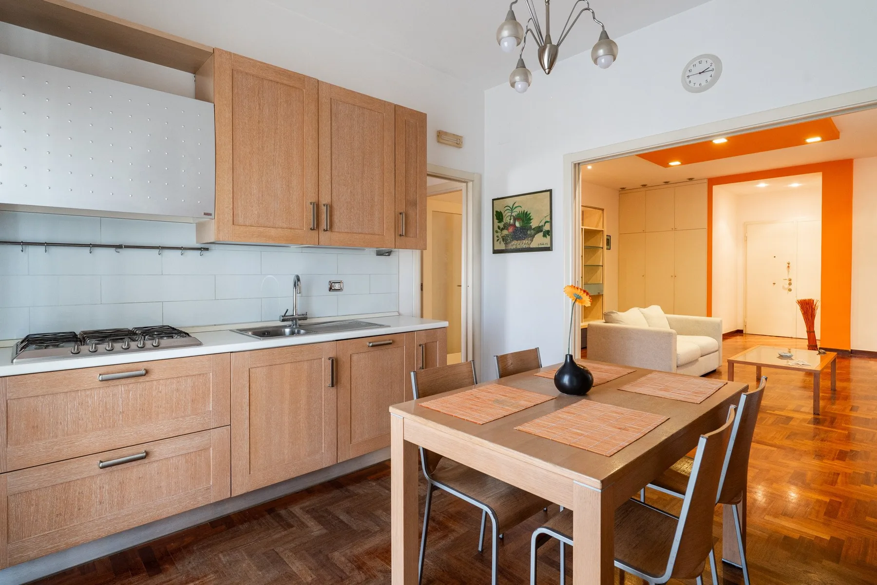 La cocina y el comedor se abren a una sala de estar con un sofá claro.
